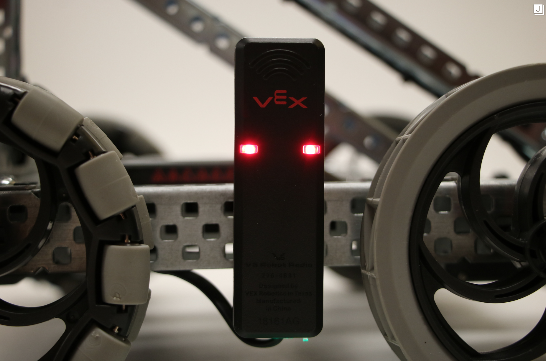 Mounted and wired V5 Robot Radio is shown on a V5 robot. In this example, the Radio's LED lights are solid red.