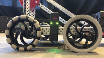Mounted and wired V5 Robot Radio is shown on a V5 robot. In this example, the Radio's LED lights are flashing green.