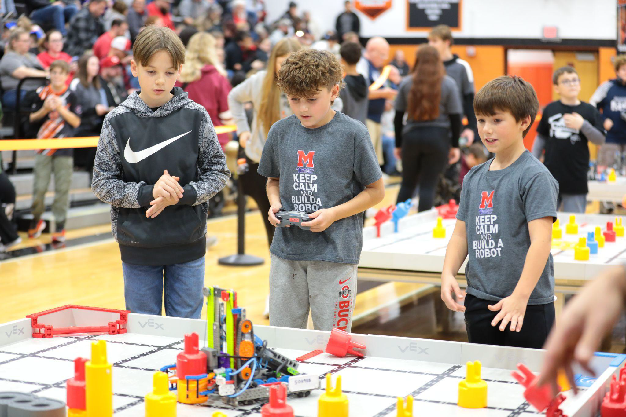 Students drive their robot on a competition field at a local event.