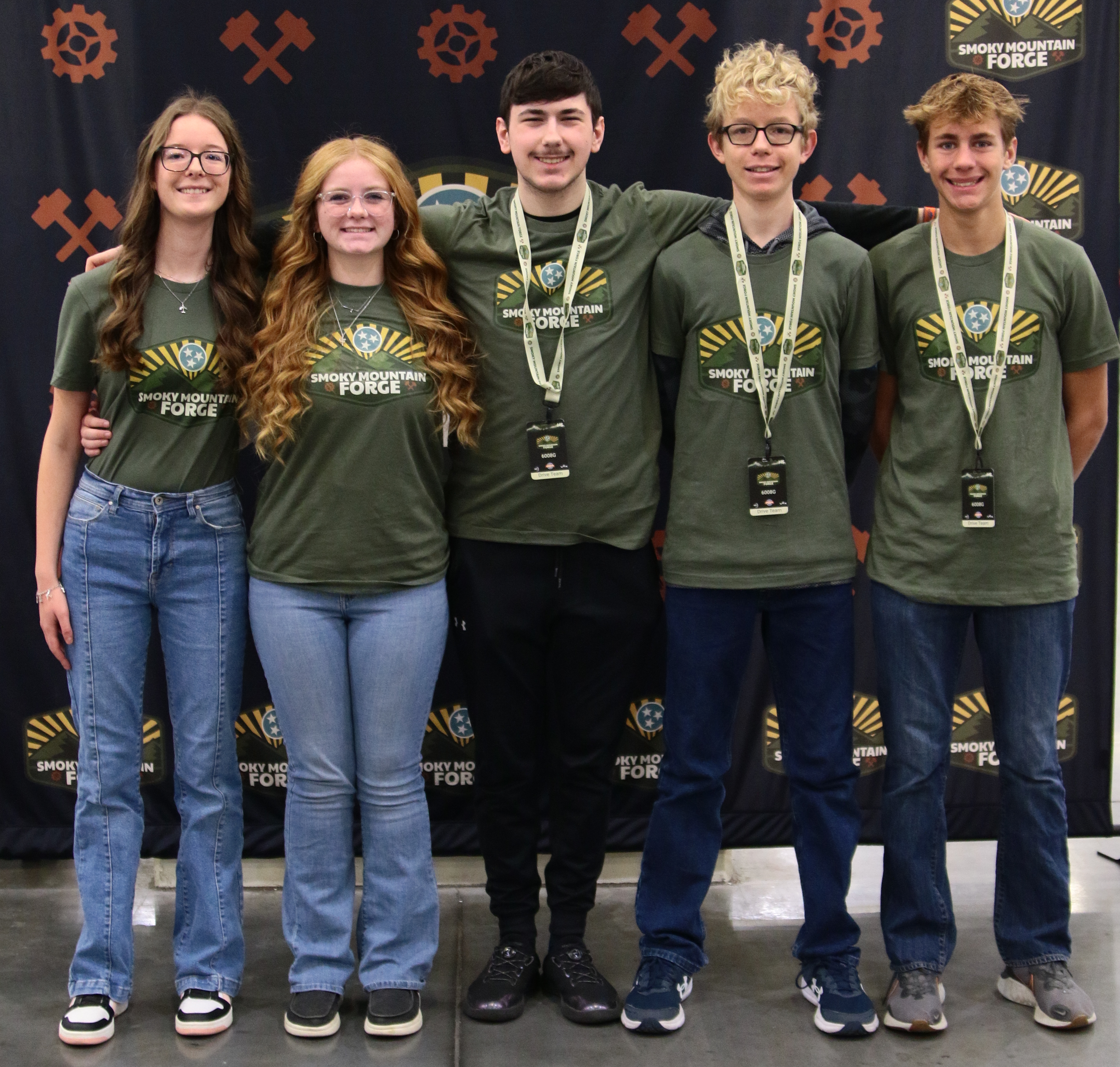 A group of people including the students and coaches of a team at a VEX Robotics competition.